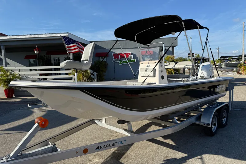 Slide: The Image of 2026 Carolina Skiff E20 JVX CC boat on trailer, parked outside dealership. - 1