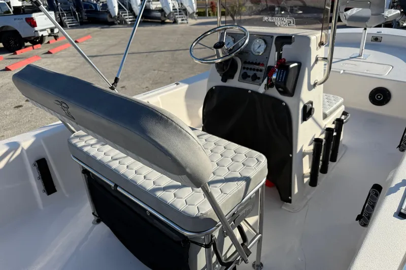 Slide: The Image of 2026 Carolina Skiff E20 JVX CC boat on display with palm trees and flags in background. - 11
