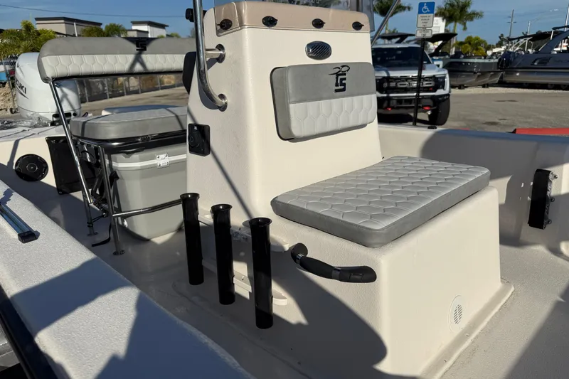 Slide: The Image of 2026 Carolina Skiff E20 JVX CC boat interior with seating and console, parked outdoors. - 12