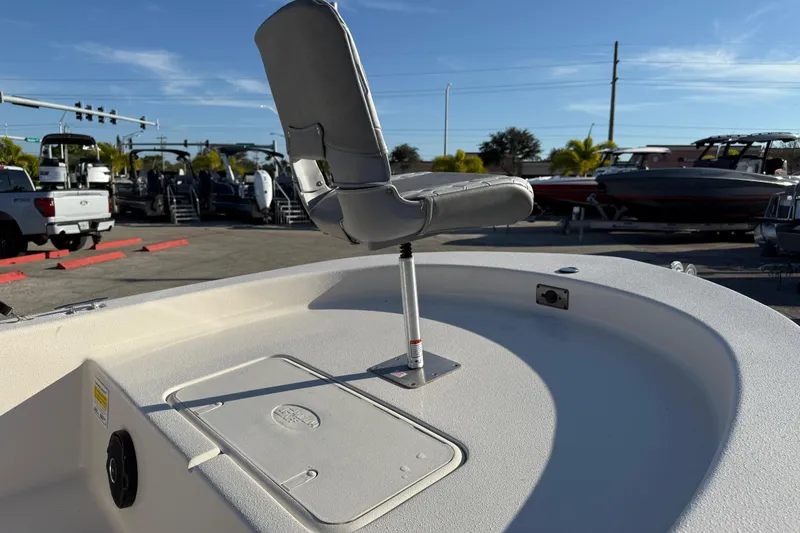 Slide: The Image of 2026 Carolina Skiff E20 JVX CC boat interior with seating and console, parked outdoors. - 13