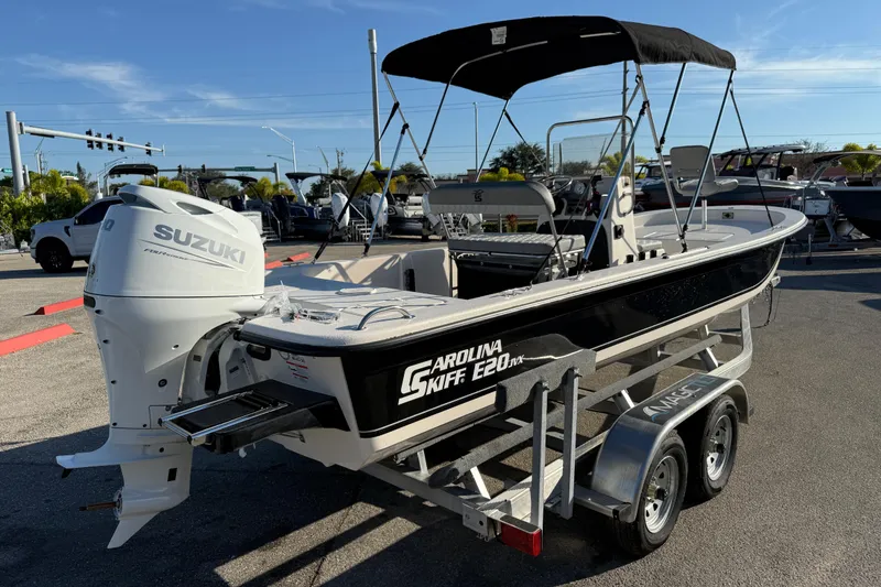 Slide: The Image of 2026 Carolina Skiff E20 JVX CC boat with Suzuki 90 engine, parked outdoors. - 5