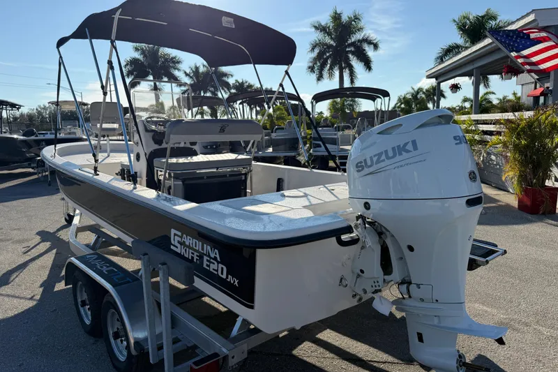 Slide: The Image of 2026 Carolina Skiff E20 JVX CC boat with Suzuki outboard motor, parked outdoors. - 7