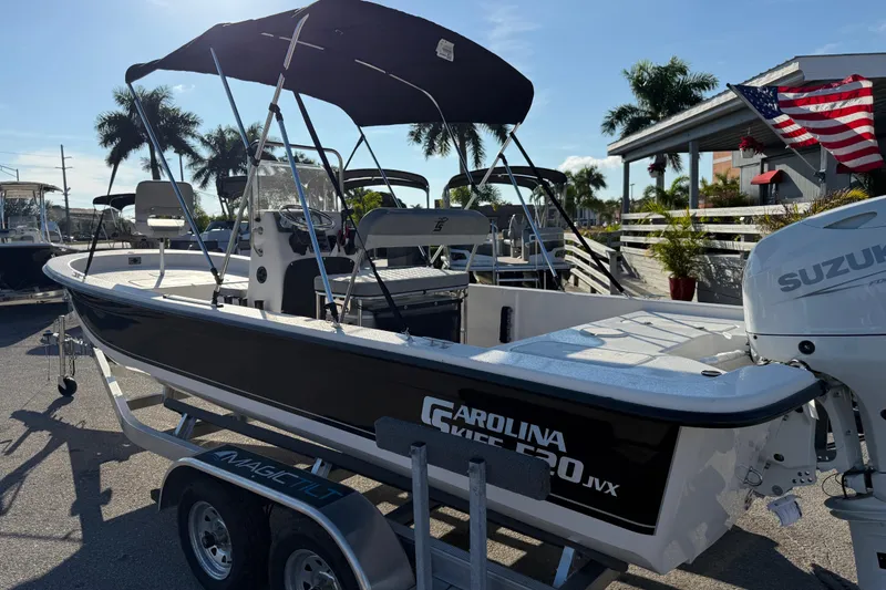 Slide: The Image of 2026 Carolina Skiff E20 JVX CC boat with Suzuki outboard motor in a marina setting. - 8