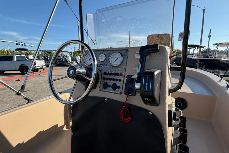 Slide: The Image of 2025 Carolina Skiff E18 JVX CC Sportman Edition boat dashboard with steering wheel and controls. - 12