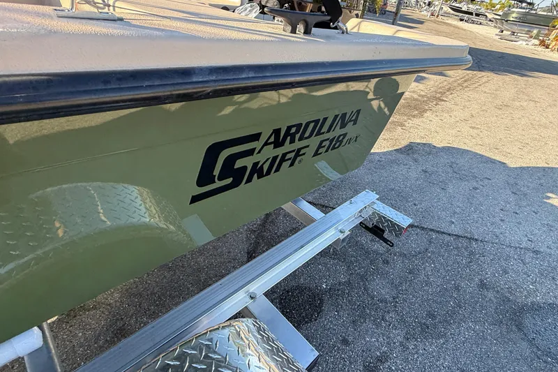 Slide: The Image of 2025 Carolina Skiff E18 JVX CC Sportman Edition on trailer, side view. - 18