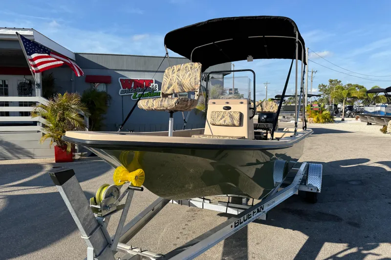 Slide: The Image of 2025 Carolina Skiff E18 JVX CC Sportman Edition boat on trailer, outdoor dealership display. - 3