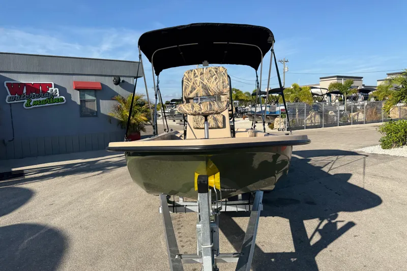 Slide: The Image of 2025 Carolina Skiff E18 JVX CC Sportman Edition boat on trailer, outdoor dealership setting. - 4