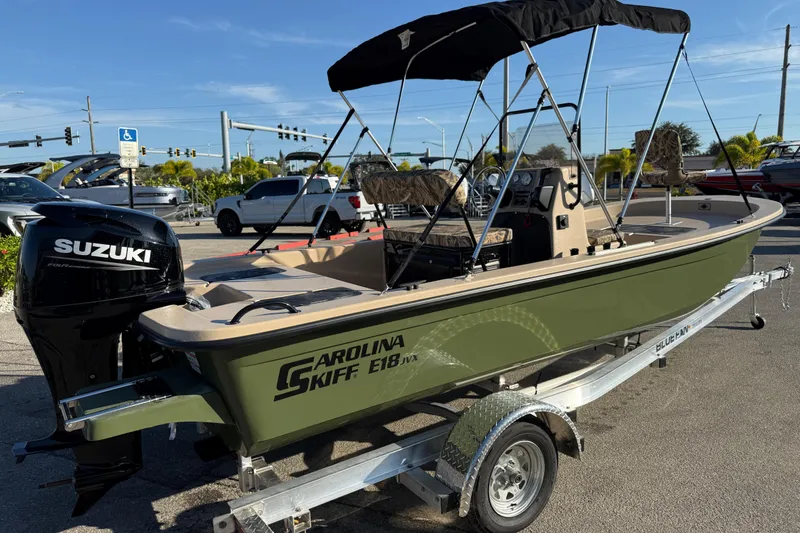 Slide: The Image of 2025 Carolina Skiff E18 JVX CC Sportman Edition boat on trailer, featuring Suzuki outboard motor. - 6