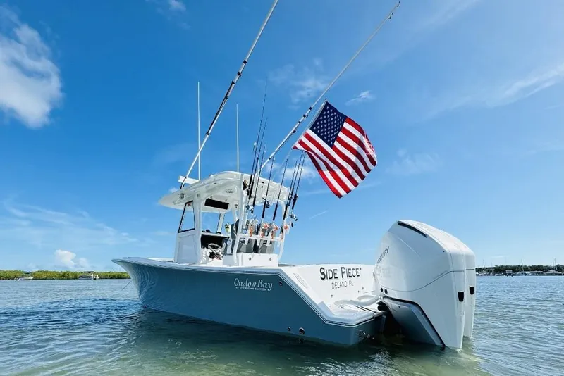 Slide: The Image of 2023 Onslow Bay 27 Offshore boat with American flag on calm water. - 4