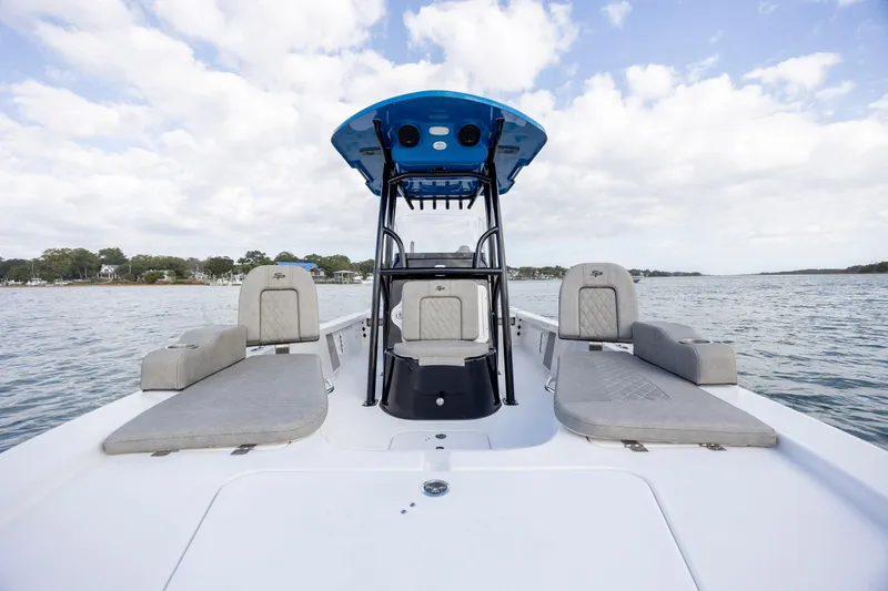 Slide: The Image of 2024 Sea Pro 228 Bay boat interior with seating, on a calm water body. - 14