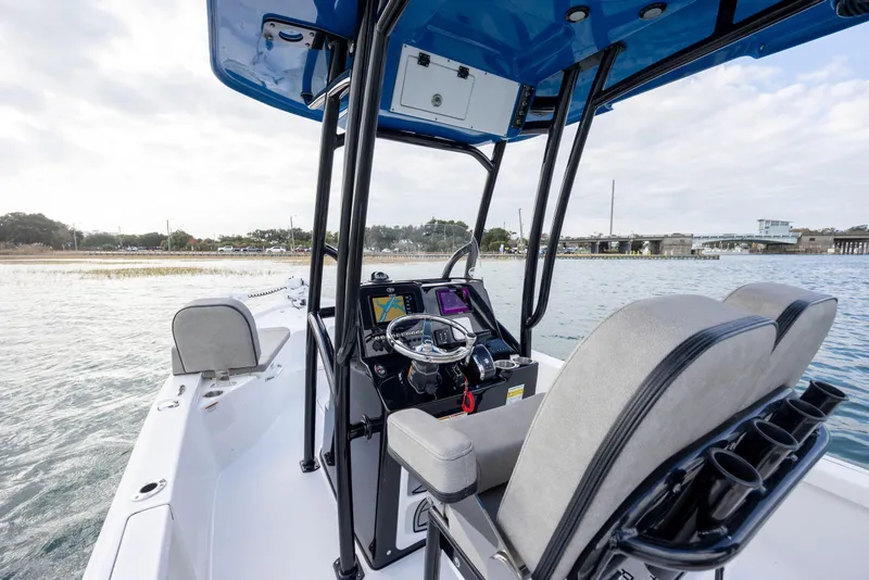 Slide: The Image of 2024 Sea Pro 228 Bay boat interior with modern console and seating on calm water. - 17