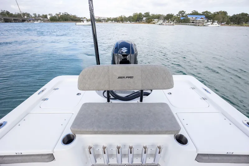 Slide: The Image of 2024 Sea Pro 228 Bay boat with cushioned seating and rod holders on a calm waterway. - 22