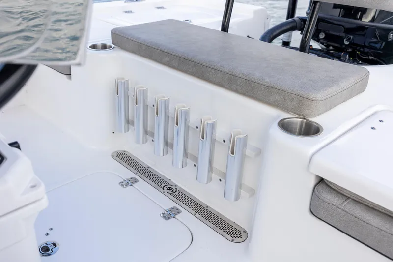 Slide: The Image of 2024 Sea Pro 228 Bay boat interior with rod holders and cushioned seating. - 23