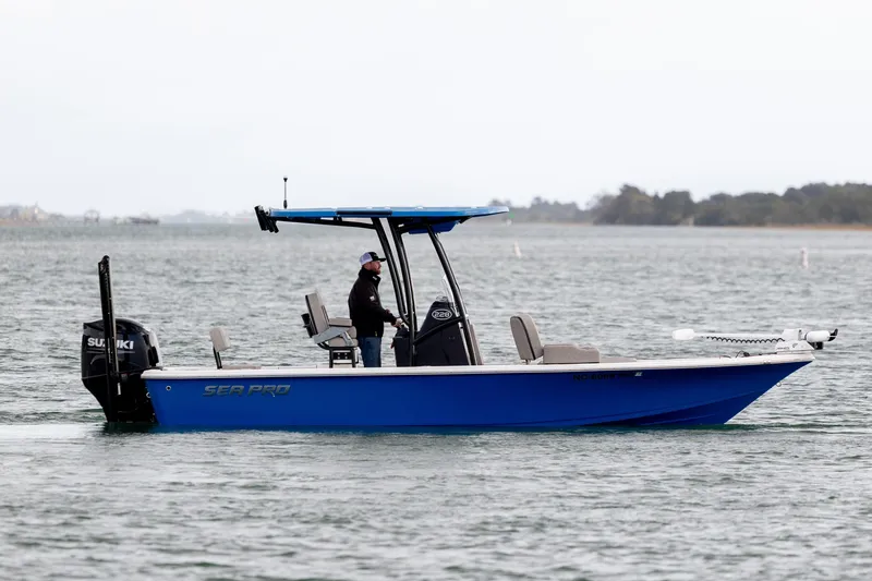 Slide: The Image of 2024 Sea Pro 228 Bay boat on water, featuring blue hull and Suzuki outboard motor. - 8