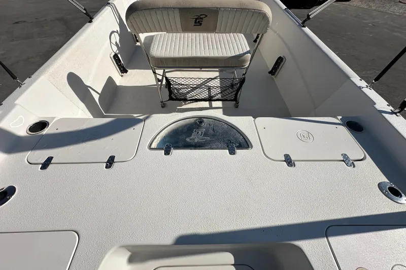 Slide: The Image of 2016 Carolina Skiff 218 DLV boat with canopy, parked in a marina. - 14
