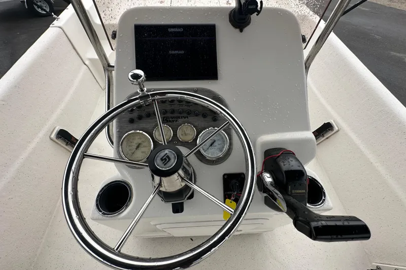Slide: The Image of 2016 Carolina Skiff 218 DLV boat console with steering wheel and Yamaha controls. - 22