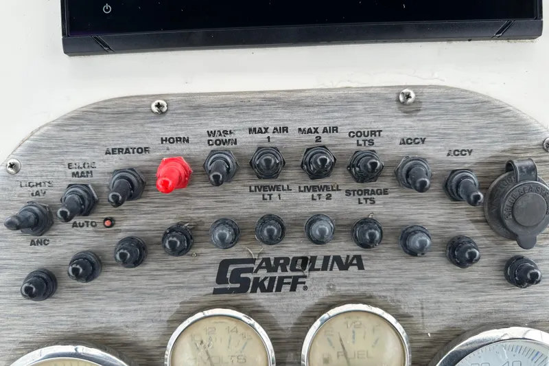 Slide: The Image of 2016 Carolina Skiff 218 DLV boat dashboard with steering wheel and controls. - 23