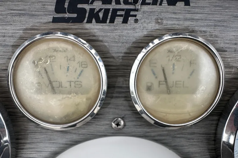 Slide: The Image of 2016 Carolina Skiff 218 DLV boat compartment with shadow and warning labels. - 24