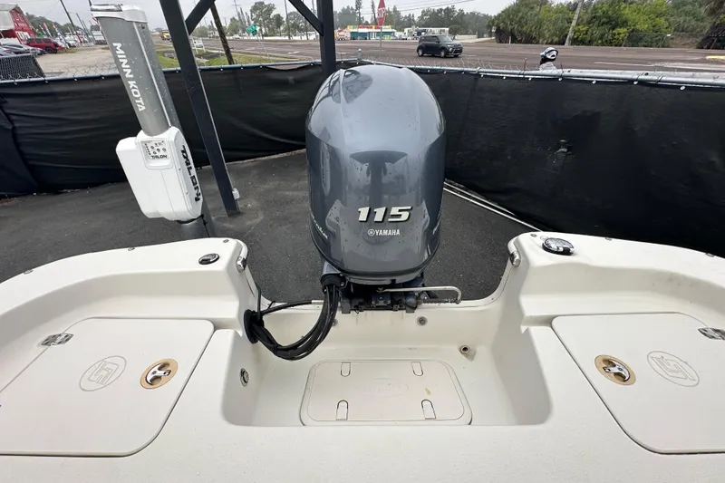 Slide: The Image of 2016 Carolina Skiff 218 DLV boat interior with seating and console, parked outdoors. - 41