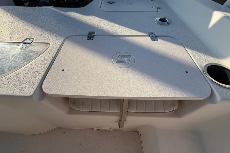 Slide: The Image of 2016 Carolina Skiff 218 DLV boat deck with storage compartments and cup holder. - 49