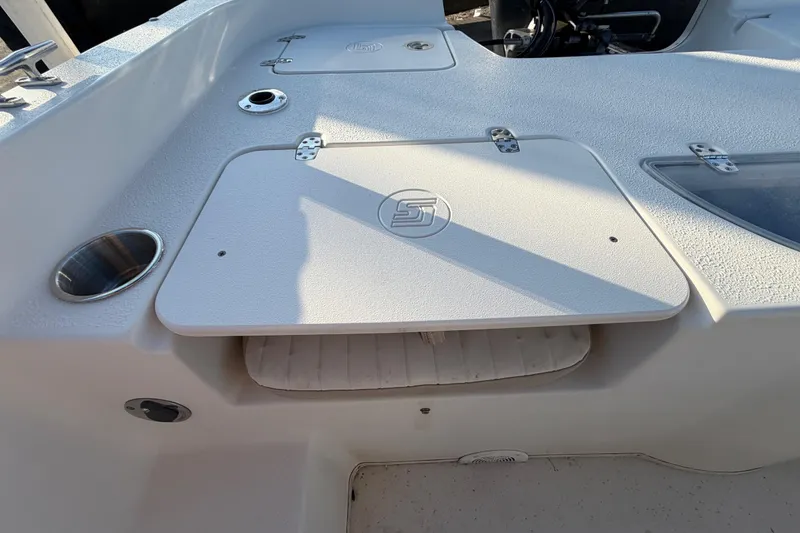 Slide: The Image of 2016 Carolina Skiff 218 DLV boat interior with storage compartment and cup holder. - 55