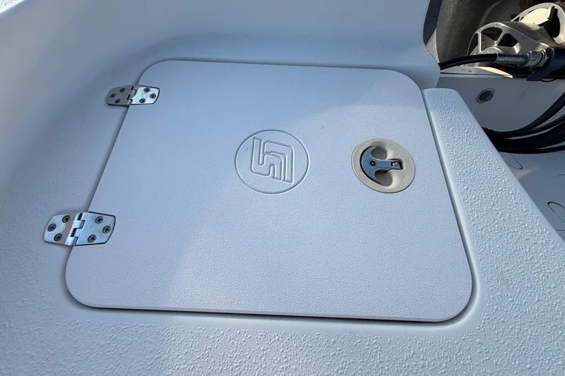 Slide: The Image of 2016 Carolina Skiff 218 DLV boat hatch with textured surface and metal hinges. - 59