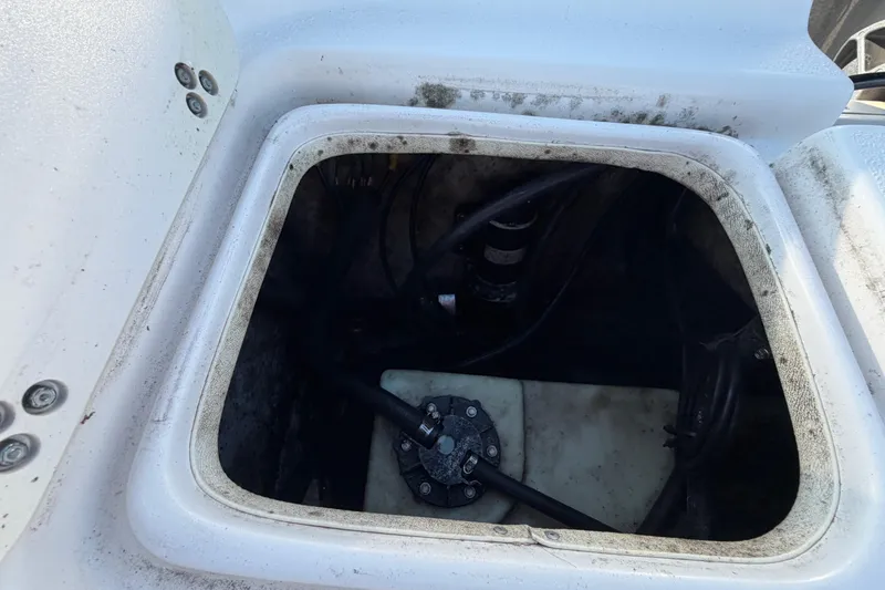 Slide: The Image of Open storage compartment of a 2016 Carolina Skiff 218 DLV boat, showing internal components. - 61