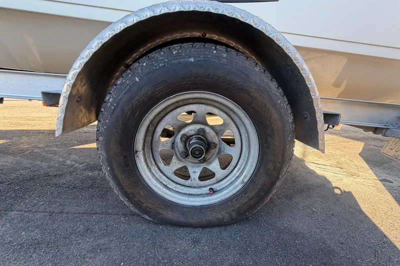 Slide: The Image of Trailer wheel of 2016 Carolina Skiff 218 DLV boat on asphalt surface. - 66