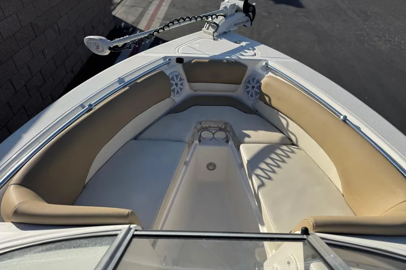Slide: The Image of 2016 Key West 211 Dual Console boat interior with tan seating and speakers. - 13