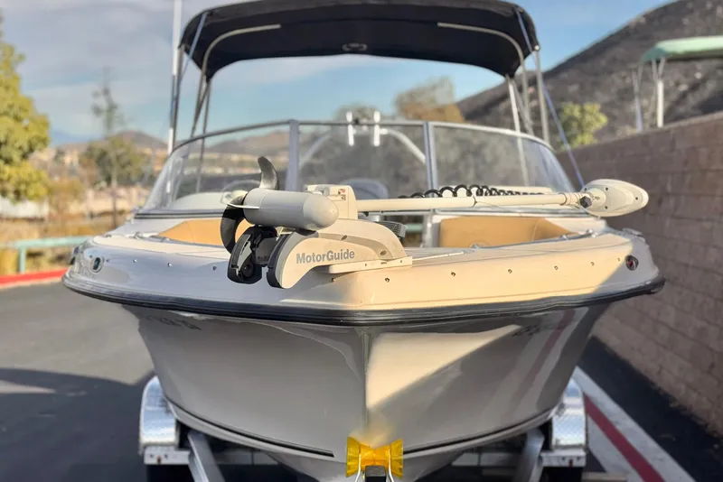 Slide: The Image of 2016 Key West 211 Dual Console boat with MotorGuide, parked on a trailer. - 2