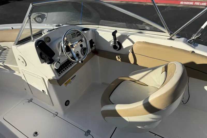 Slide: The Image of 2016 Key West 211 Dual Console boat interior with steering wheel and seating. - 27