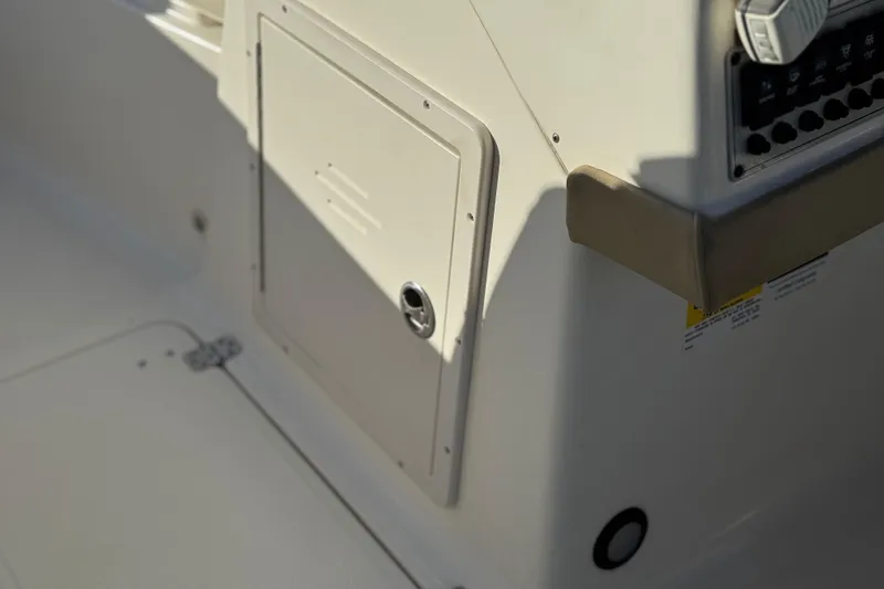 Slide: The Image of 2016 Key West 211 Dual Console boat interior with control panel and storage compartment. - 29