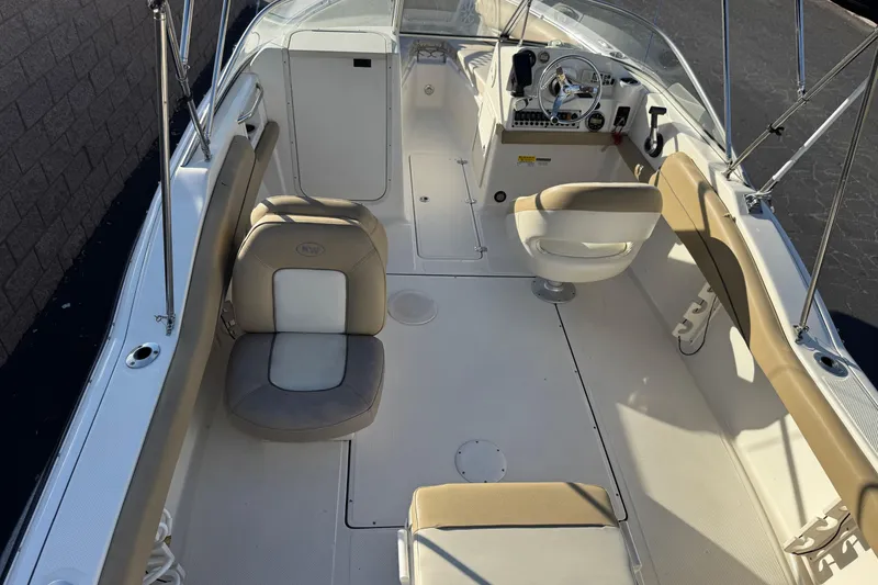 Slide: The Image of 2016 Key West 211 Dual Console boat interior with beige seating and steering console. - 9