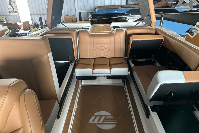 Slide: The Image of 2026 Malibu Wakesetter 23 LSV interior with tan leather seating and storage compartments. - 17
