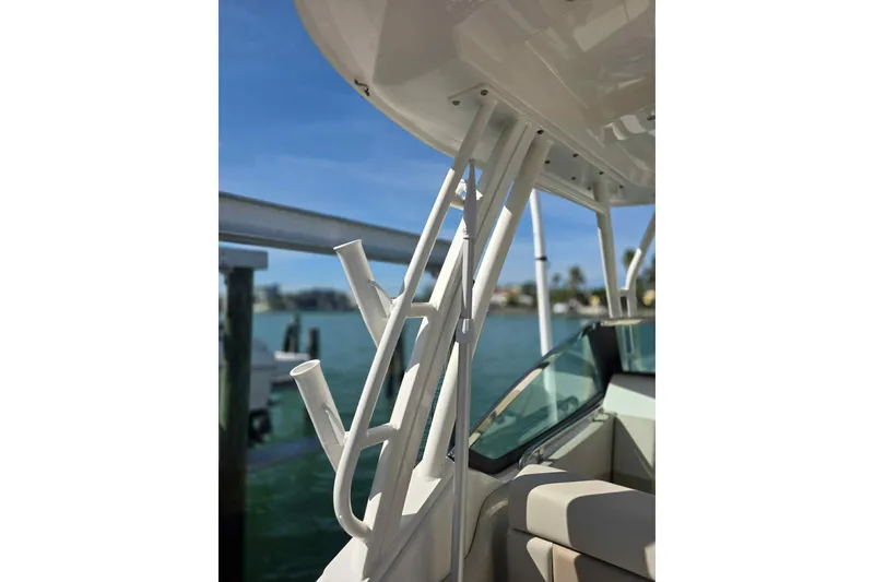 Slide: The Image of 2021 Boston Whaler 240 Vantage boat with rod holders and seating, docked by the water. - 28