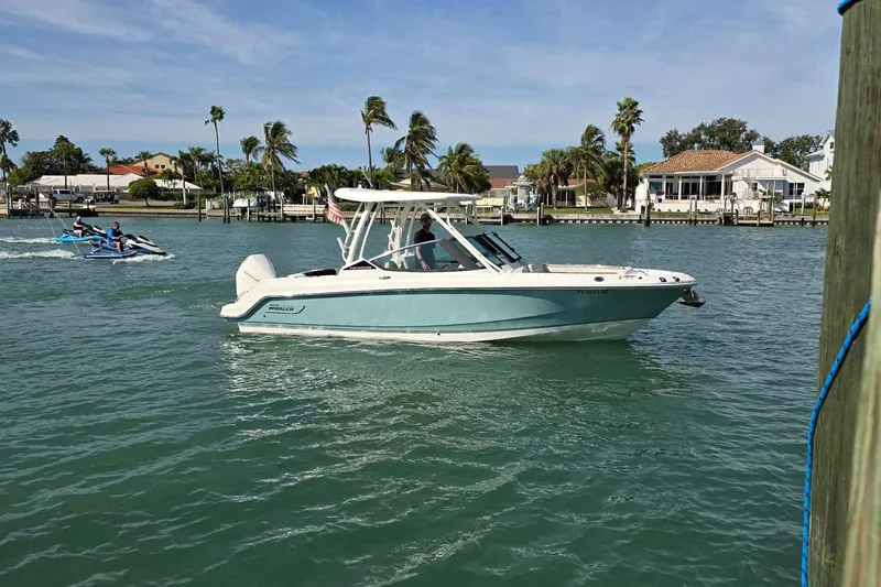 Slide: The Image of 2021 Boston Whaler 240 Vantage boat cruising on a sunny waterfront with palm trees. - 3