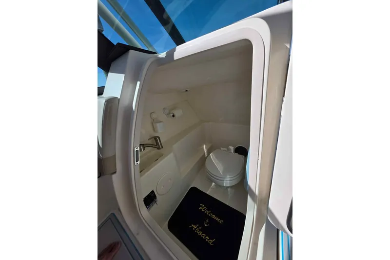 Slide: The Image of 2021 Boston Whaler 240 Vantage boat interior with compact restroom and welcome mat. - 32