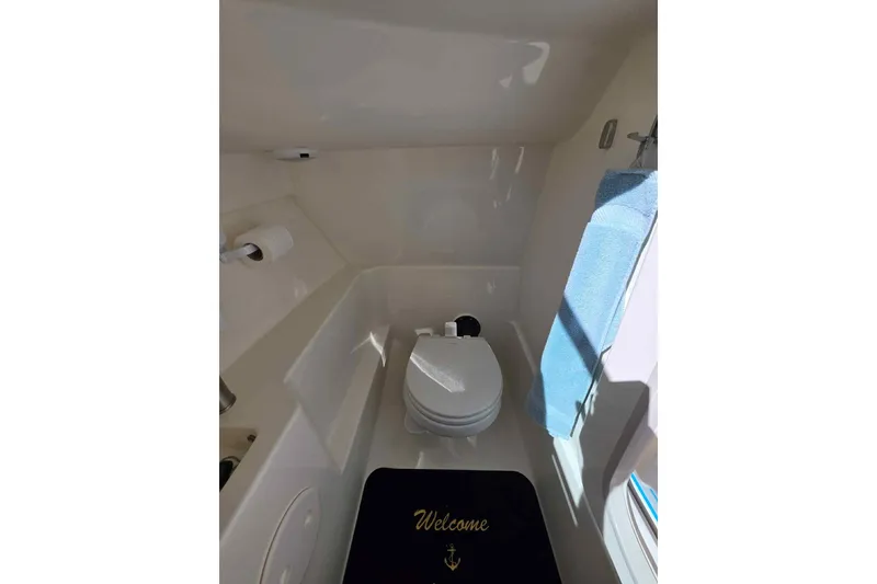 Slide: The Image of 2021 Boston Whaler 240 Vantage boat interior with toilet and welcome mat. - 33