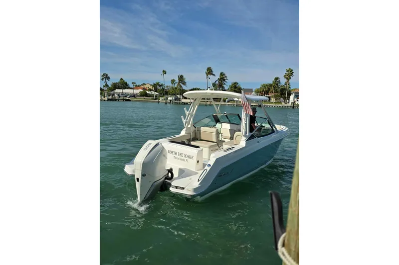 Slide: The Image of 2021 Boston Whaler 240 Vantage boat on water, sunny day, palm trees in background. - 4