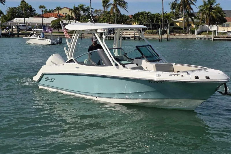 Slide: The Image of 2021 Boston Whaler 240 Vantage boat cruising on a sunny day with palm trees in the background. - 7