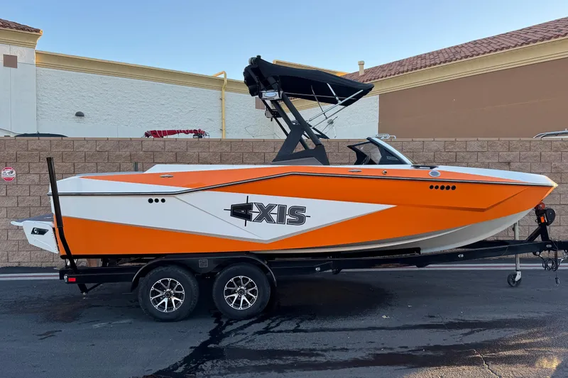 The Image of 2023 Axis T220 boat in vibrant orange and white, parked on a trailer. - 0
