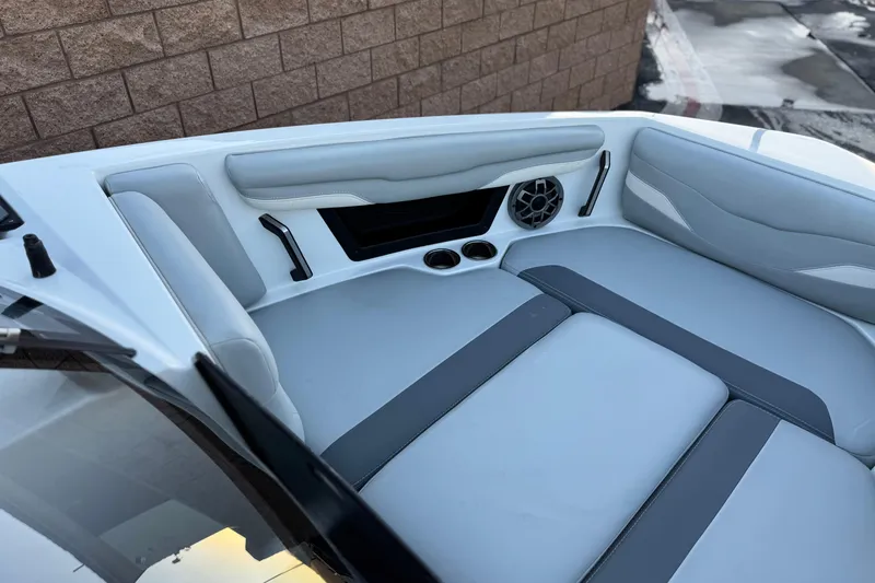 Slide: The Image of 2023 Axis T220 boat interior with gray seating, cup holders, and speaker system. - 15