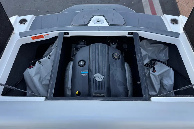 Slide: The Image of 2023 Axis T220 boat engine compartment with visible engine and storage bags. - 19