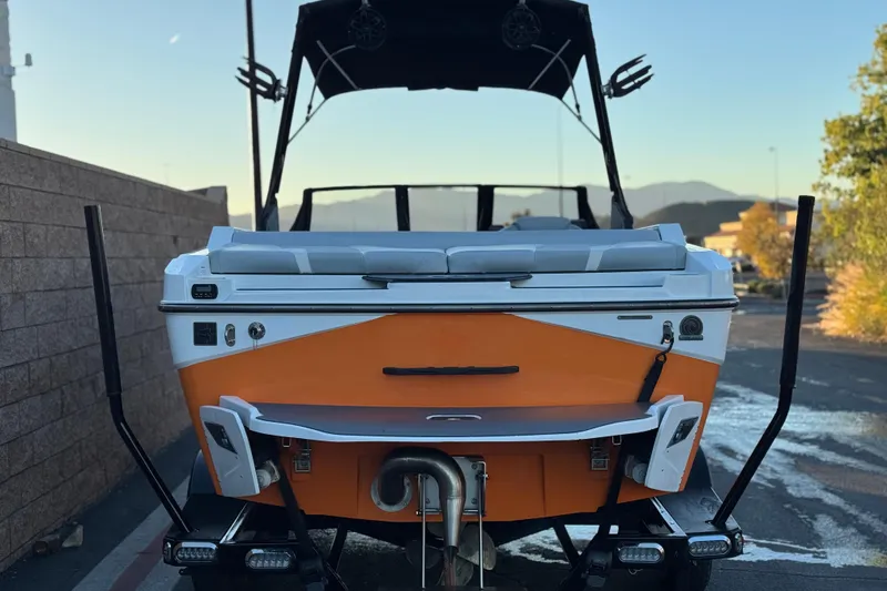 Slide: The Image of 2023 Axis T220 boat, orange and white, rear view with wakeboard tower. - 4