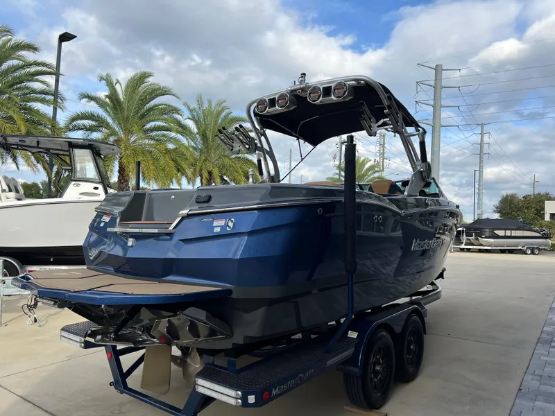 Slide: The Image of 2019 MasterCraft XStar boat on trailer, palm trees in background. - 7