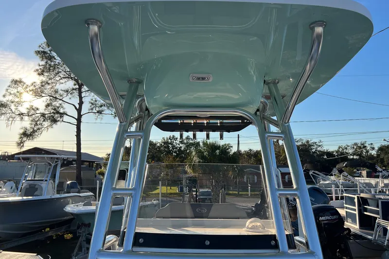 Slide: The Image of 2026 Key West 219 FS boat with T-top and Mercury engine, docked outdoors. - 11