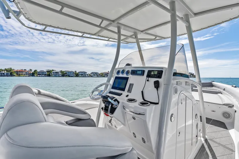 Slide: The Image of Cockpit of 2014 Airship 330 boat with modern controls, overlooking serene waterfront homes. - 11