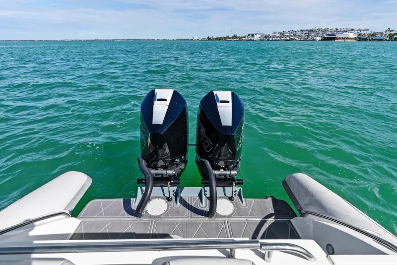 Slide: The Image of Twin outboard motors on a 2014 Airship 330 boat, cruising on clear blue water. - 17