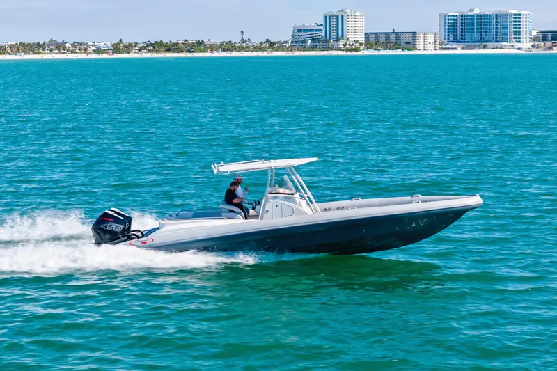 Slide: The Image of 2014 Airship 330 boat cruising on turquoise water near a coastal cityscape. - 2