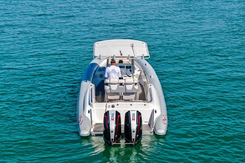 Slide: The Image of Airship 330 boat from 2014 on clear blue water, rear view with dual engines. - 6